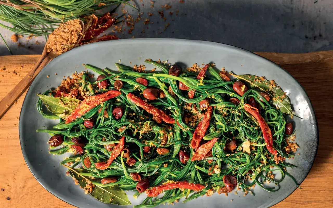 Agretti in padella con olive, pomodori secchi e pangrattato croccante. Un piatto colorato e saporito.
