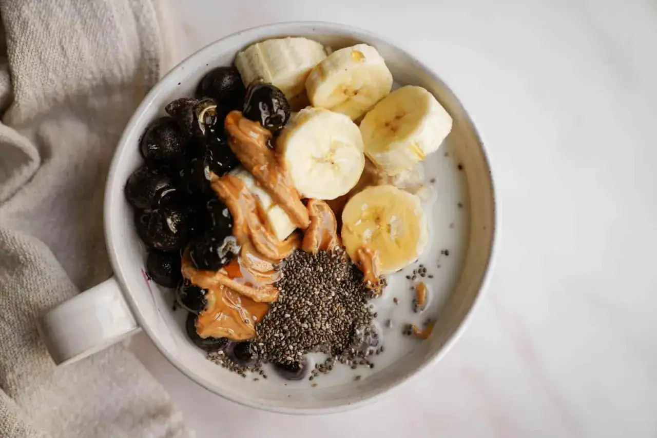 Porridge con mirtilli, banana, burro d'arachidi e semi di chia: perfetti esempi di colazione a basso indice glicemico per iniziare la giornata con energia.