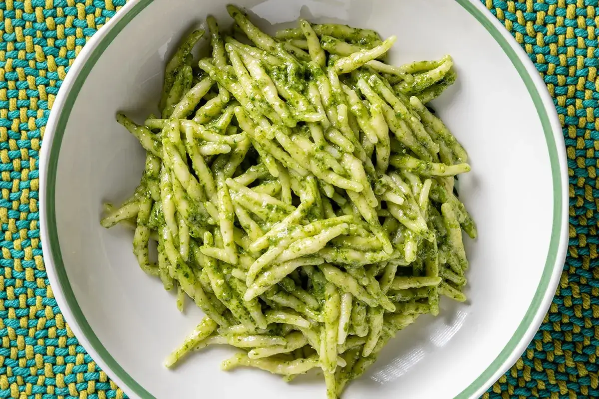 Un piatto di trofie al pesto, un classico della cucina ligure, pronto per essere gustato.