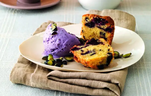 Frumina, cosa è? Un delizioso dolce con mirtilli e gelato viola, guarnito con frutta fresca.