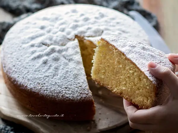 Una fetta di torta Margherita, soffice e cosparsa di zucchero a velo, pronta per essere gustata. La ricetta perfetta per un dolce casalingo.
