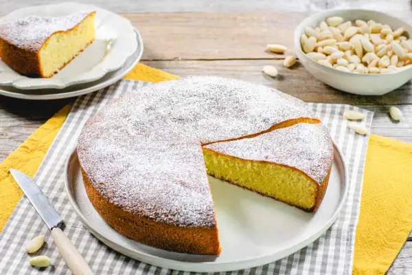 Torta soffice con farina di mandorle, spolverata di zucchero a velo, pronta per essere gustata.