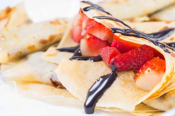 Crepes ricetta senza burro con fragole fresche e salsa al cioccolato. Deliziose e leggere, perfette per ogni occasione.