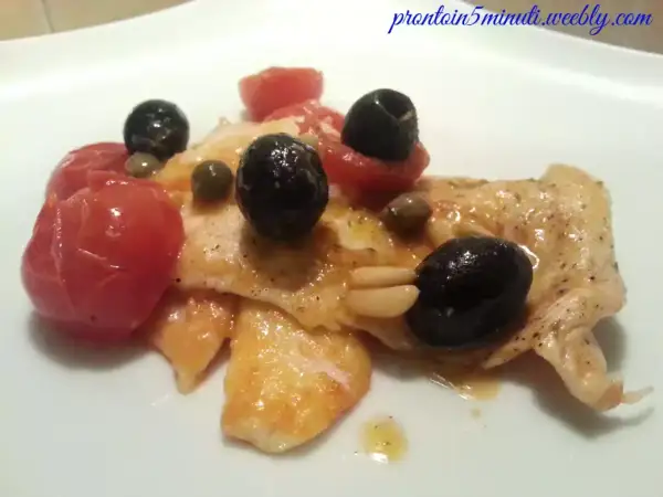 Petto di pollo cotto con pomodorini, olive nere, capperi e pinoli. Un modo diverso per preparare il petto di pollo.